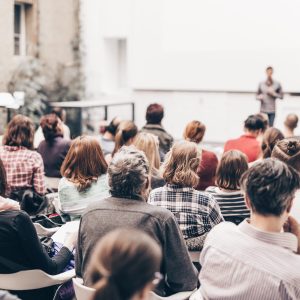 Rear View Of People Sitting In Auditorium